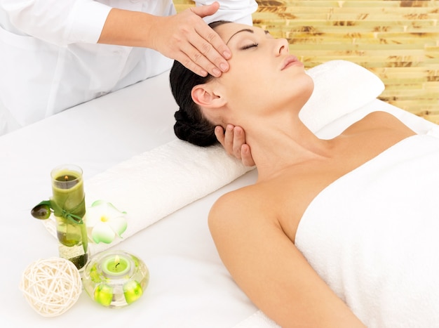 Vrouw met massage van gezicht in de spa salon. Schoonheidsbehandeling concept.