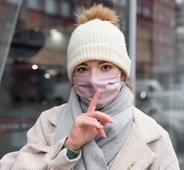 Vrouw met medisch masker in de stad die stilte eist