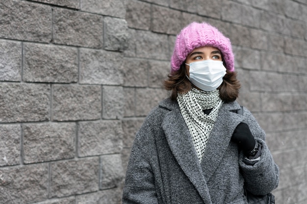 Vrouw met medisch masker in de stad met exemplaarruimte