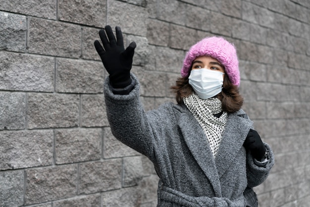 Vrouw met medisch masker in het zwaaien van de stad