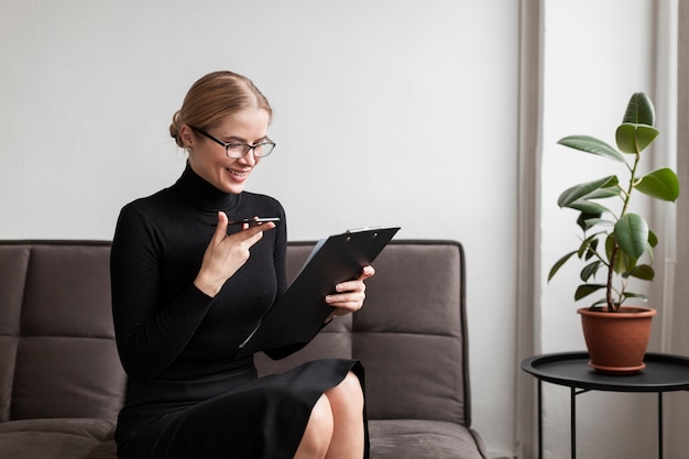 Vrouw met mobiel en klembord