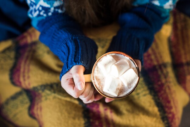 Vrouw met mok met drankje en marshmallows