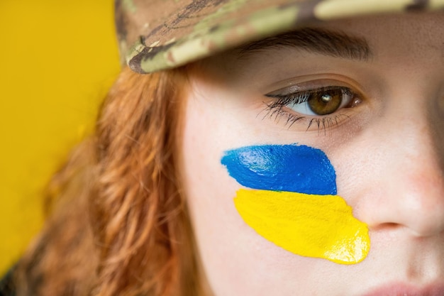 Vrouw met nationale vlaggen van Oekraïne op haar wangen
