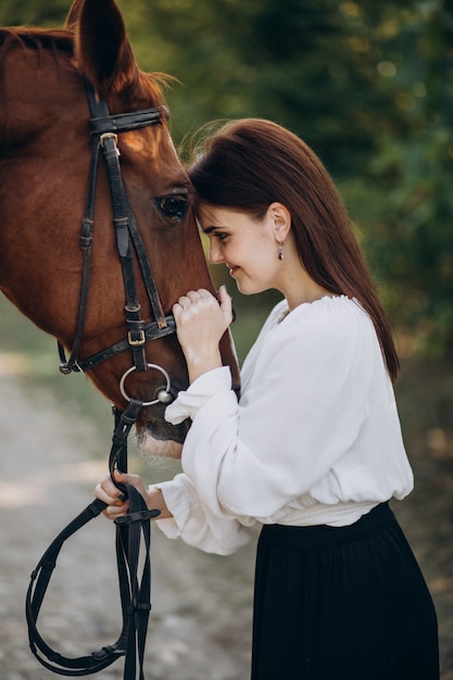 Vrouw met paard in bos