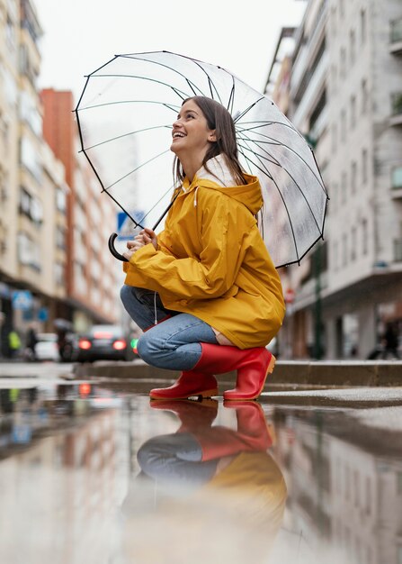 Vrouw met paraplu staande in het zijaanzicht van de regen