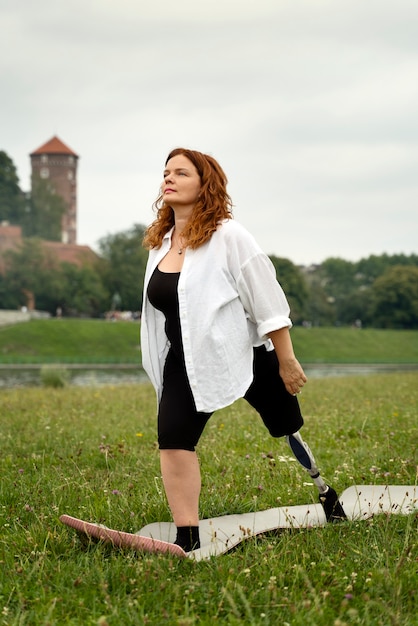 Vrouw met prothetisch been die yoga doet