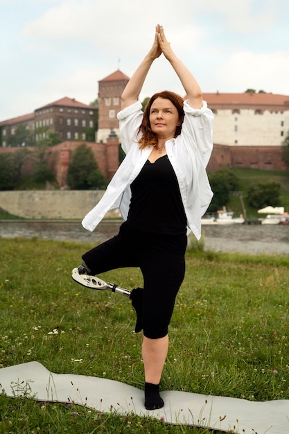 Vrouw met prothetisch been die yoga doet