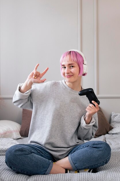 Vrouw met roze haar die een videogame speelt