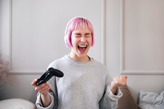 Vrouw met roze haar die een videogame speelt