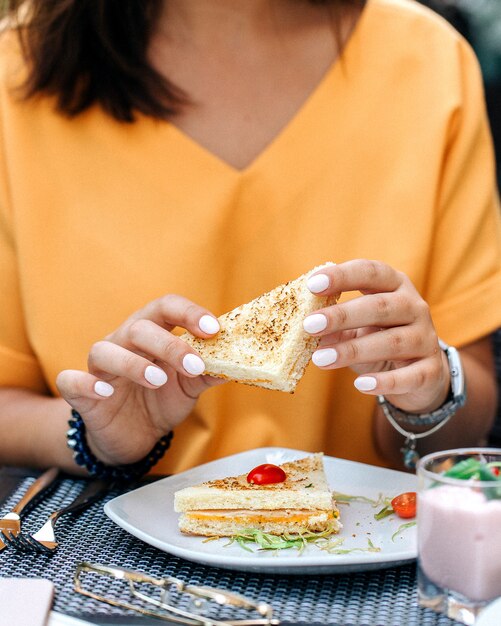 Vrouw met sandwich in handen