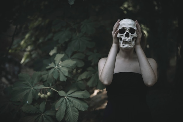Vrouw met schedel in bos