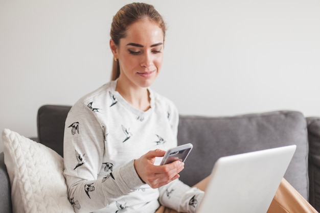 Vrouw met smartphone en laptop