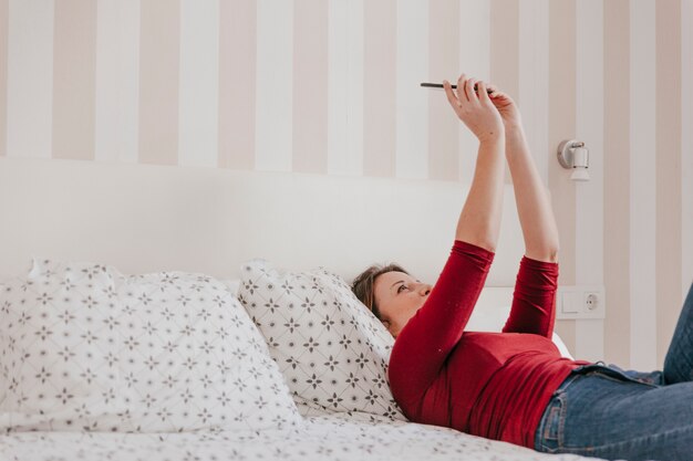 Vrouw met smartphone in bed