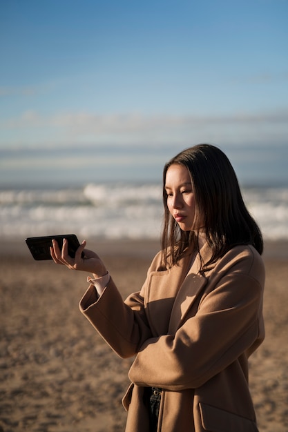 Gratis foto vrouw met smartphone zijaanzicht