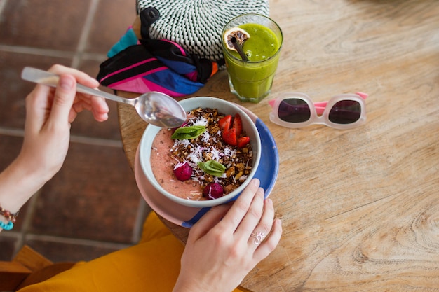 Vrouw met smoothie. Superfoods kom gegarneerd met chia, granola en avocado.