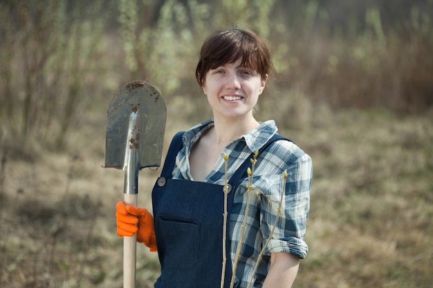 Vrouw met spade en spruit in het voorjaar