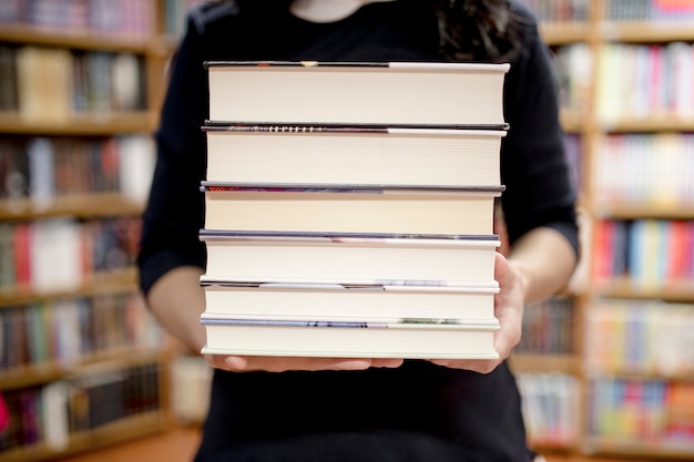 Vrouw met stapel boeken bijsnijden