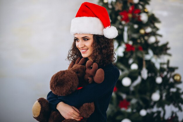 Vrouw met stuk speelgoed Amerikaanse elanden door Kerstmisboom