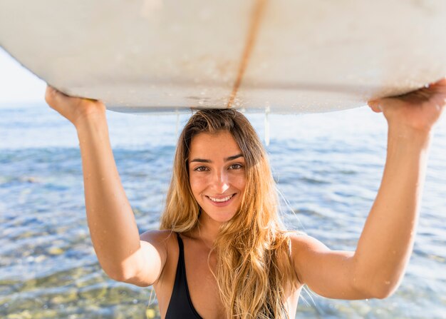 Vrouw met surfplank op het strand