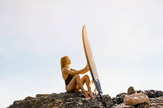 Vrouw met surfplank op het strand