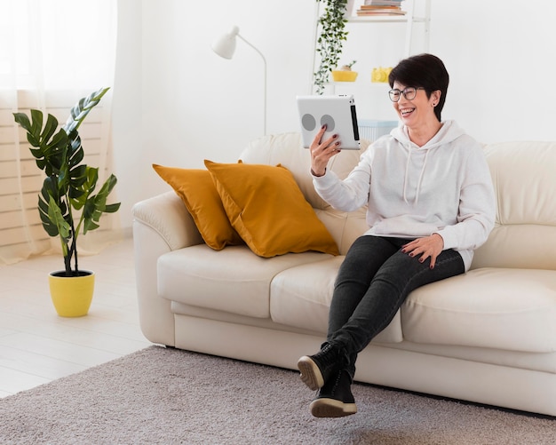 Gratis foto vrouw met tablet op sofa