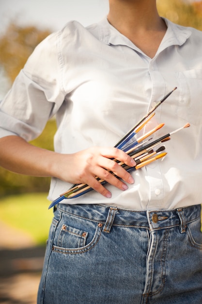 Gratis foto vrouw met verf penselen buitenshuis