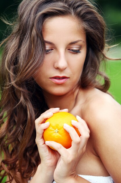 Vrouw met verse sinaasappelen in haar handen