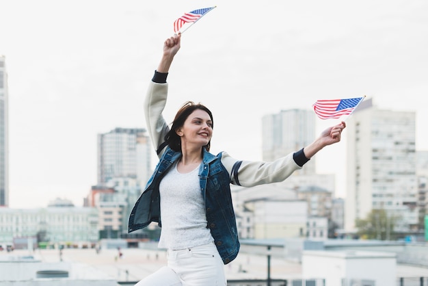 Vrouw met vlaggen op Independence Day of America zwaaien