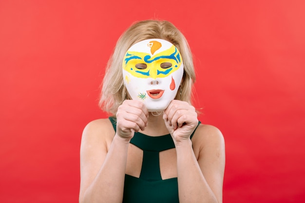 Gratis foto vrouw met wit carnaval-masker in handen