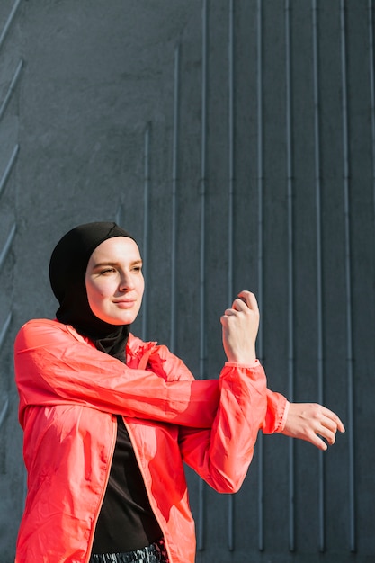 Vrouw met zich het rode jas uitrekken