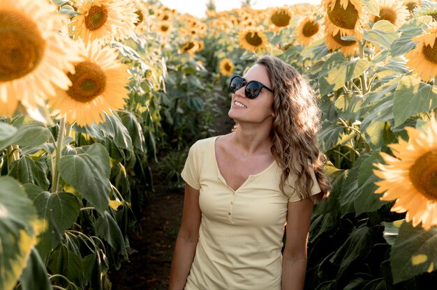 Vrouw met zonnebril op zonnebloemgebied