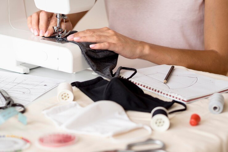 Gratis Foto vrouw naaien gezichtsmasker met laptop
