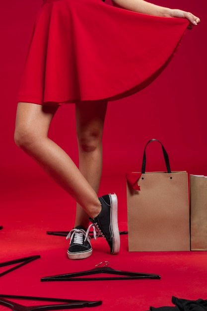 Gratis foto vrouw naast het winkelen zakken op de vloer met rode achtergrond