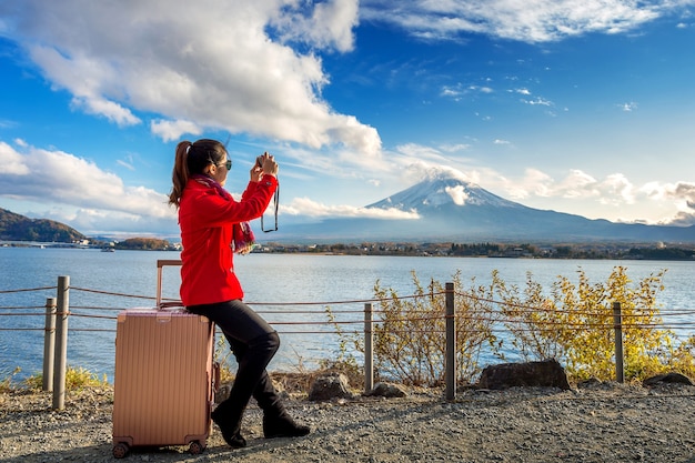 Vrouw neemt een foto bij fuji-bergen. herfst in japan. reis concept.