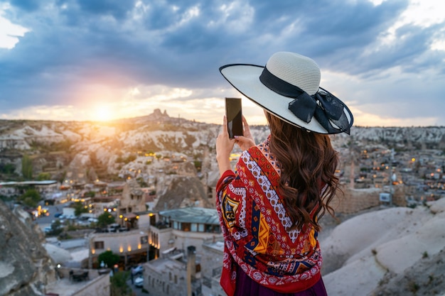 Gratis foto vrouw neemt een foto met haar smartphone in goreme, cappadocië in turkije.