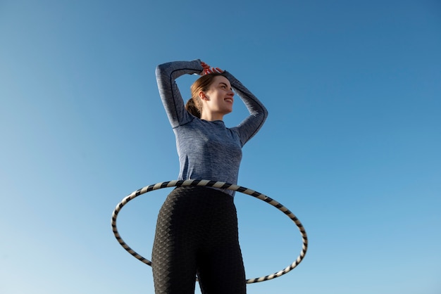 Gratis foto vrouw oefenen met hoelahoep cirkel