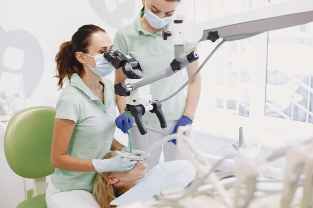 vrouw onder tandheelkundige behandeling op het kantoor van de tandarts en vrouw wordt behandeld voor tanden.
