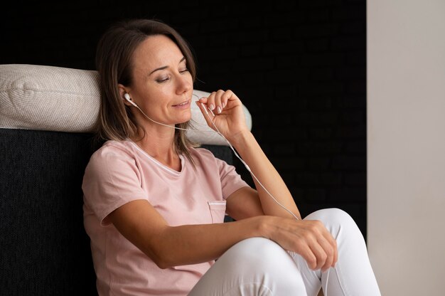 Vrouw ontspannen terwijl ze thuis naar muziek luistert
