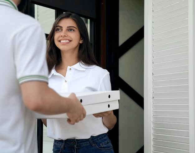 Vrouw ontvangt pizza van koerier