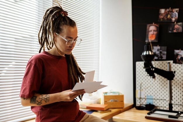 Gratis foto vrouw ontwikkelt foto's in een medium shot in een donkere kamer