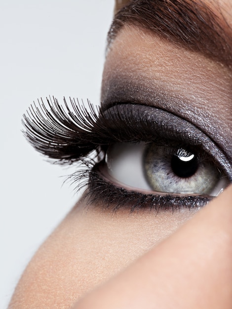 Gratis foto vrouw oog met zwarte oogmake-up. macro-stijl afbeelding. lange wimpers