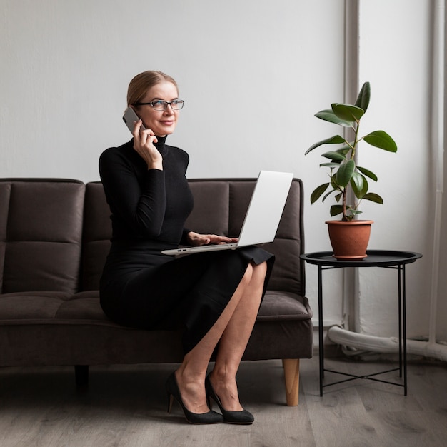 Gratis foto vrouw op bank die bij telefoon spreekt