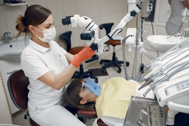 Vrouw op het kantoor van de tandarts. Arts voert een onderzoek. Meisje behandelt haar tanden