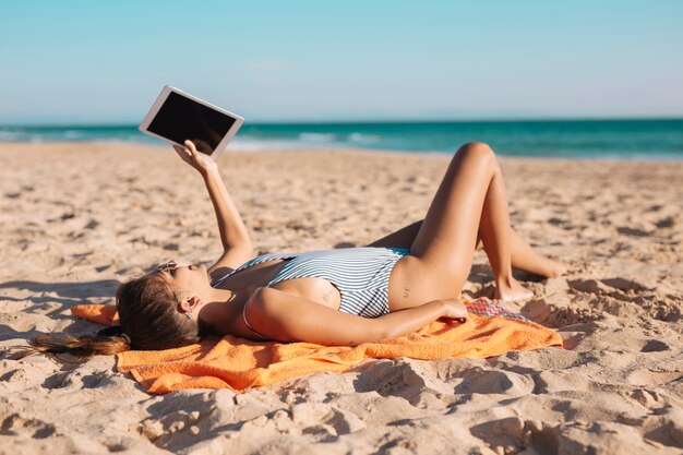 Vrouw op strand met tablet