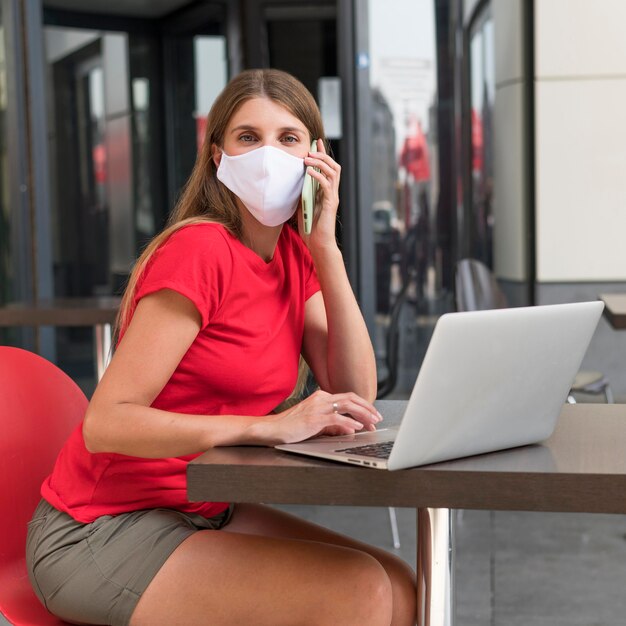 Vrouw op terras met gezichtsmasker