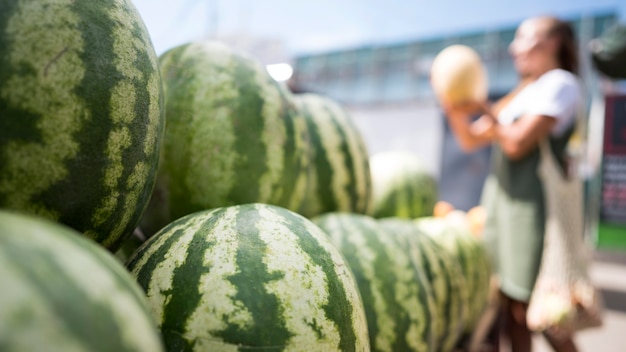 Gratis foto vrouw op zoek naar een verse watermeloen met kopie ruimte