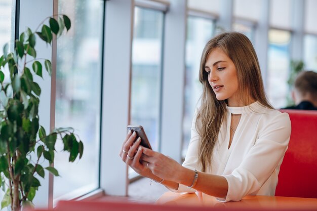 Vrouw op zoek naar haar telefoon zitten in een coffeeshop