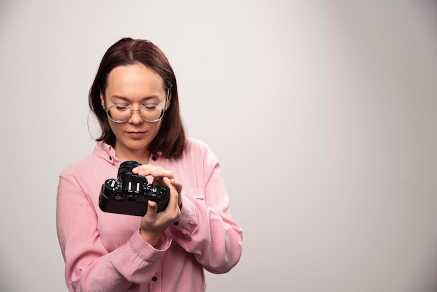 Vrouw op zoek op een camera op een wit. Hoge kwaliteit foto