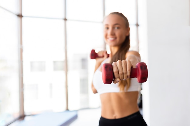 Vrouw opleiding met gewichten in gymnastiek