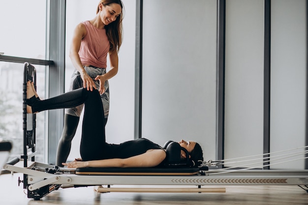 Vrouw opleiding pilates op de hervormer